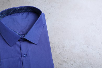 Photo of Stylish blue shirt on grey background, top view with space for text. Dry-cleaning service