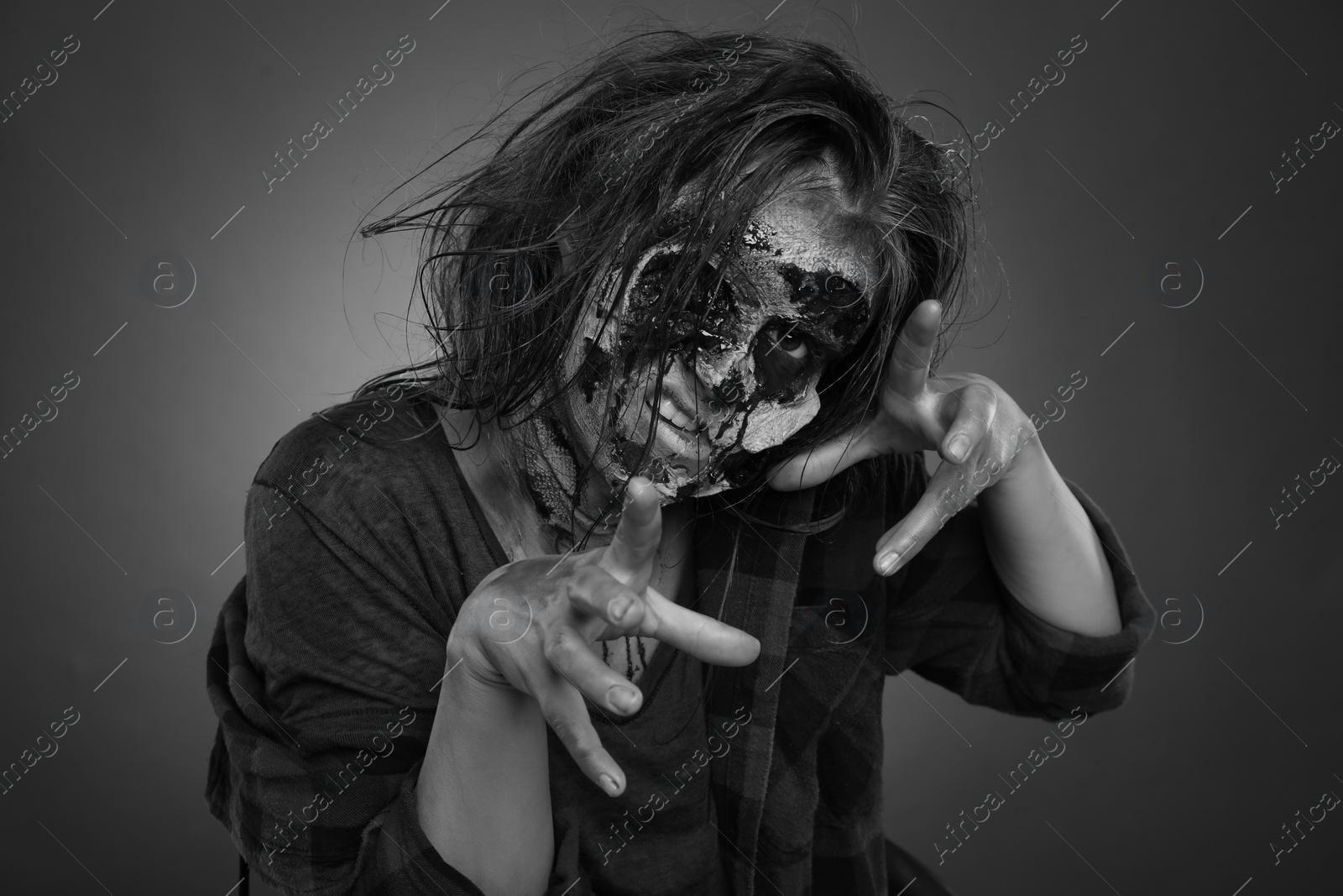 Photo of Scary zombie on dark background, black and white effect. Halloween monster