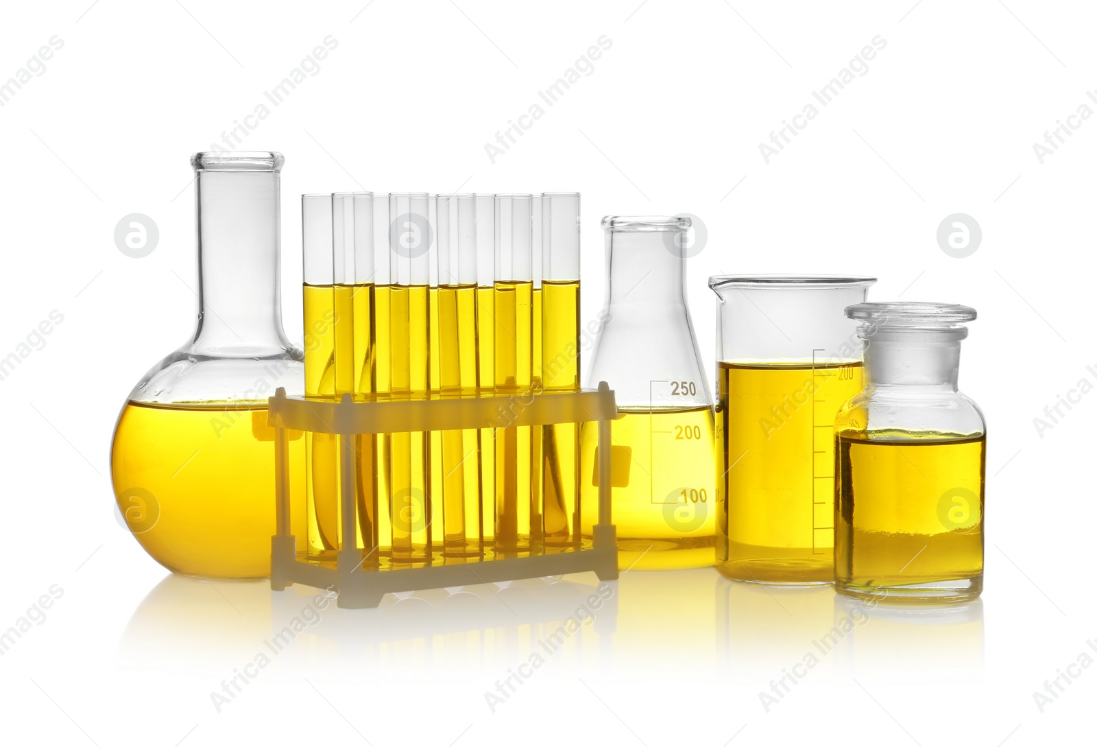 Photo of Laboratory glassware with yellow liquid on white background