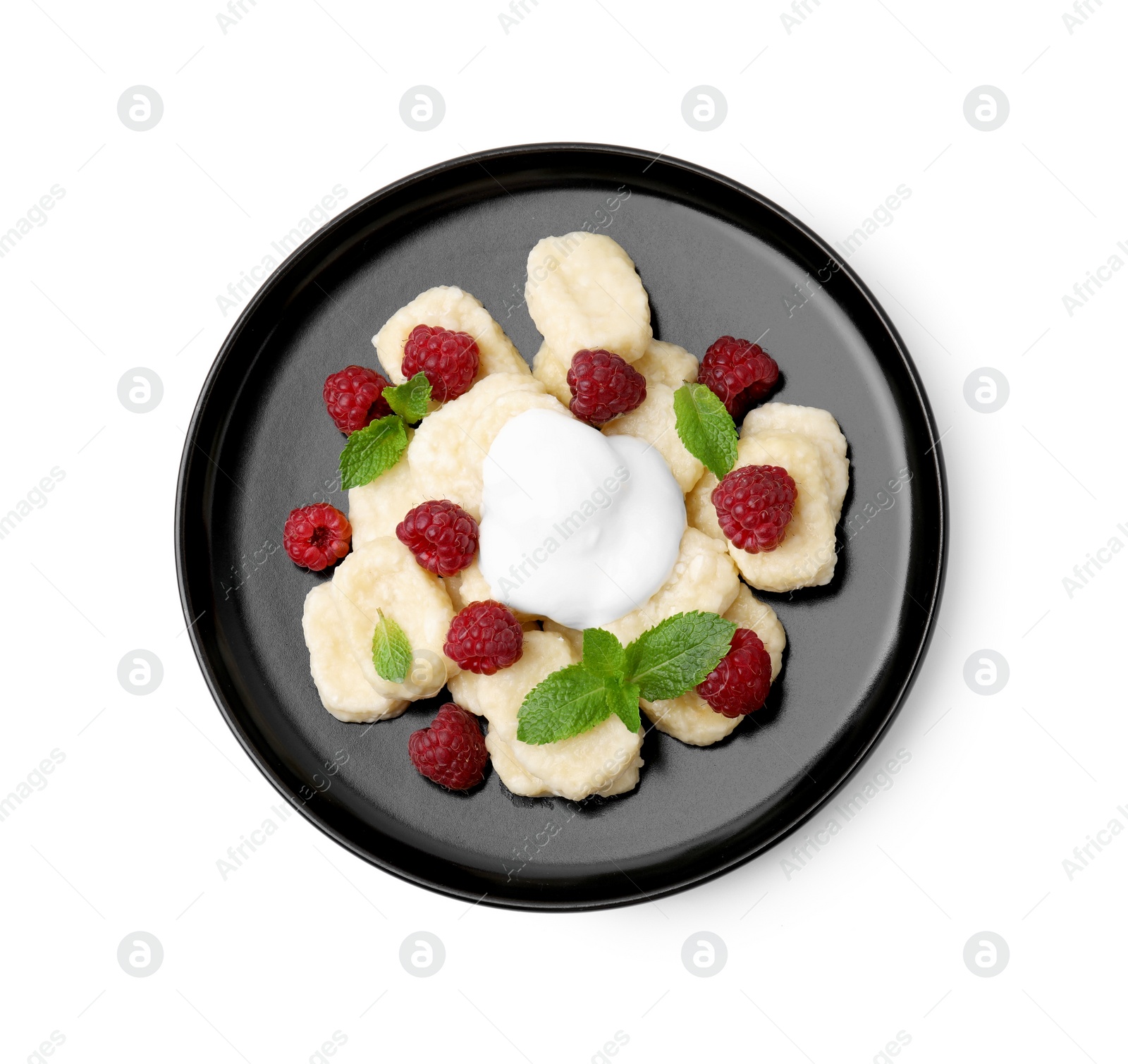 Photo of Plate of tasty lazy dumplings with raspberries, sour cream and mint leaves isolated on white, top view