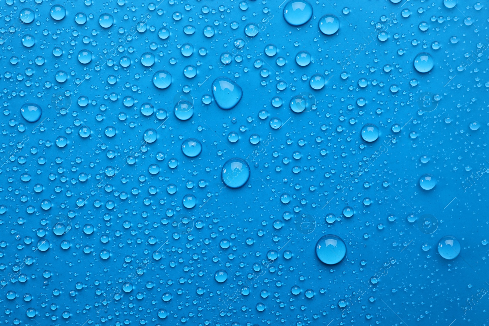 Photo of Water drops on light blue background, top view