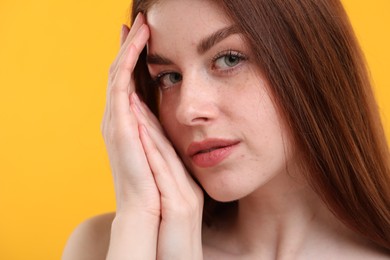 Photo of Portrait of beautiful woman with freckles on yellow background, closeup