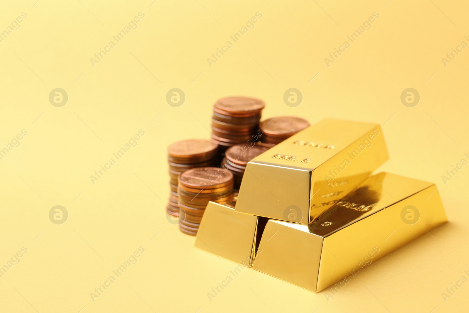 Photo of Shiny gold bars and coins on color background