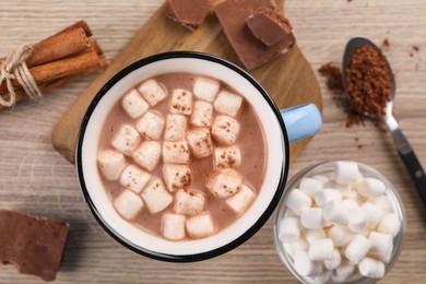 Cup of aromatic hot chocolate with marshmallows and cocoa powder served on table, flat lay