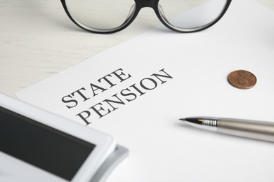 Photo of Paper with words STATE PENSION, coins, calculator and glasses on table