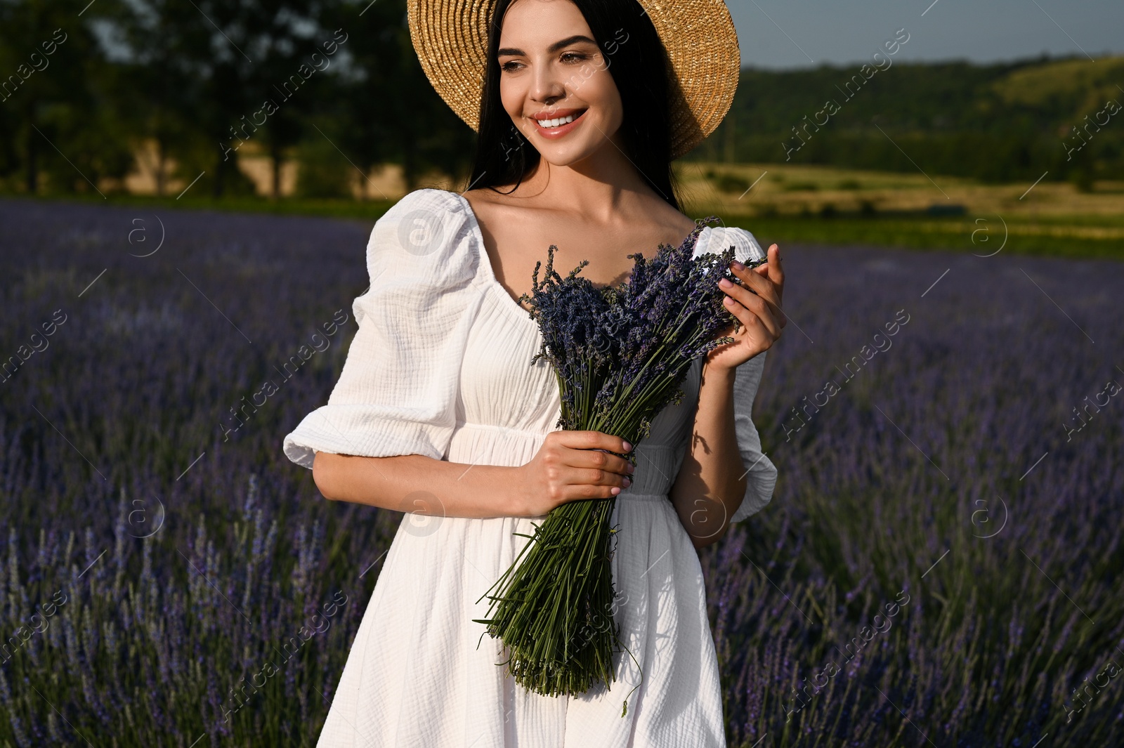 Photo of Beautiful young woman with bouquet in lavender field