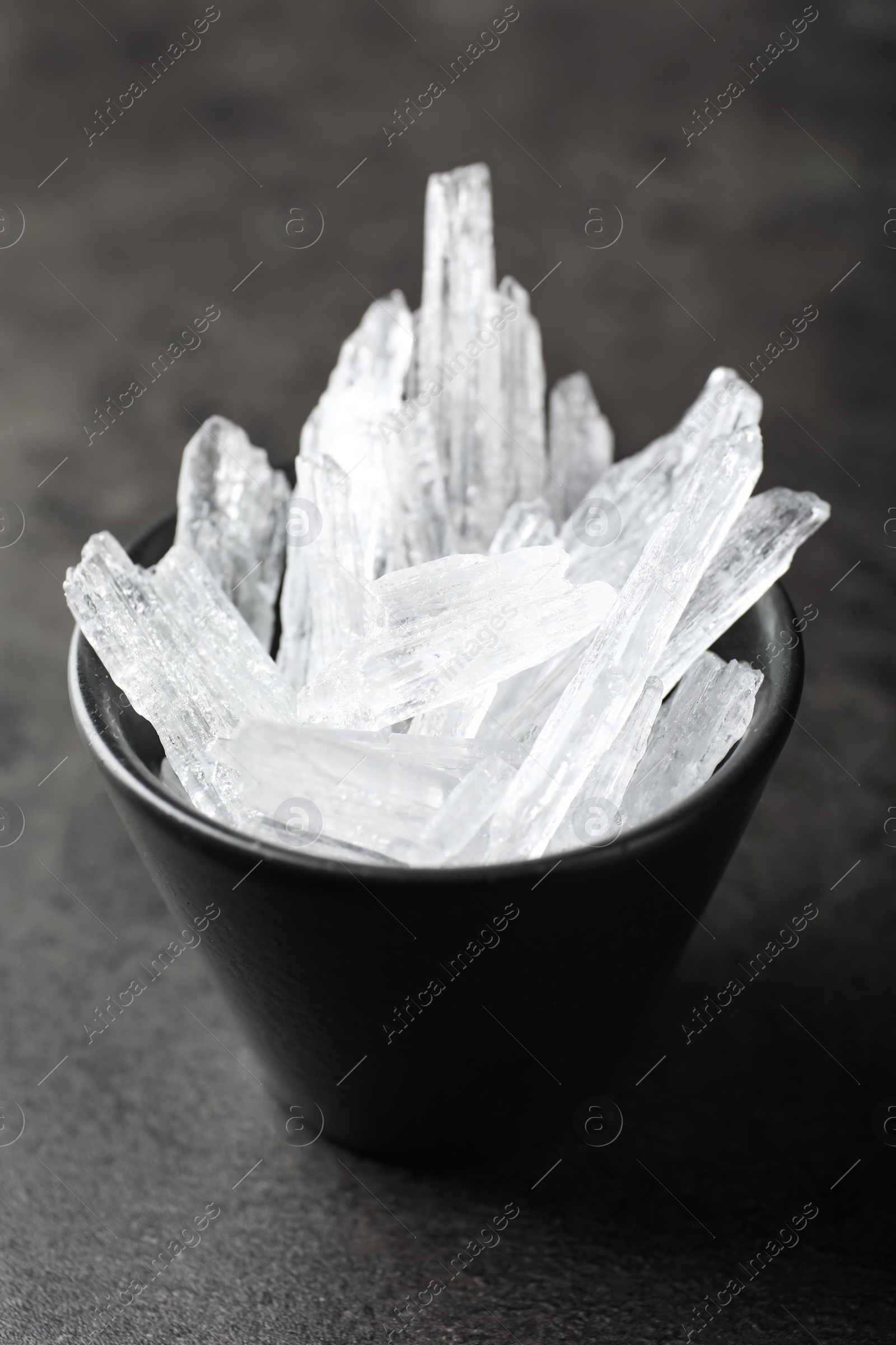 Photo of Menthol crystals in bowl on grey background