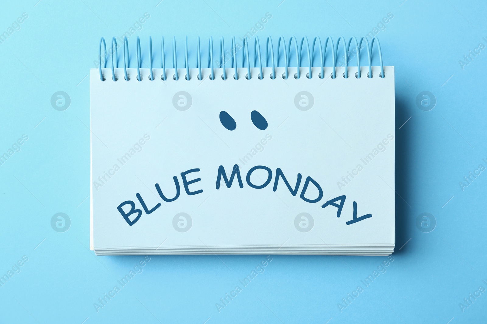 Image of Notebook with text Blue Monday on color background, top view