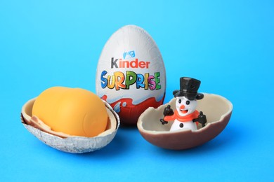 Photo of Slynchev Bryag, Bulgaria - May 25, 2023: Kinder Surprise Eggs, plastic capsule and toy snowman on light blue background