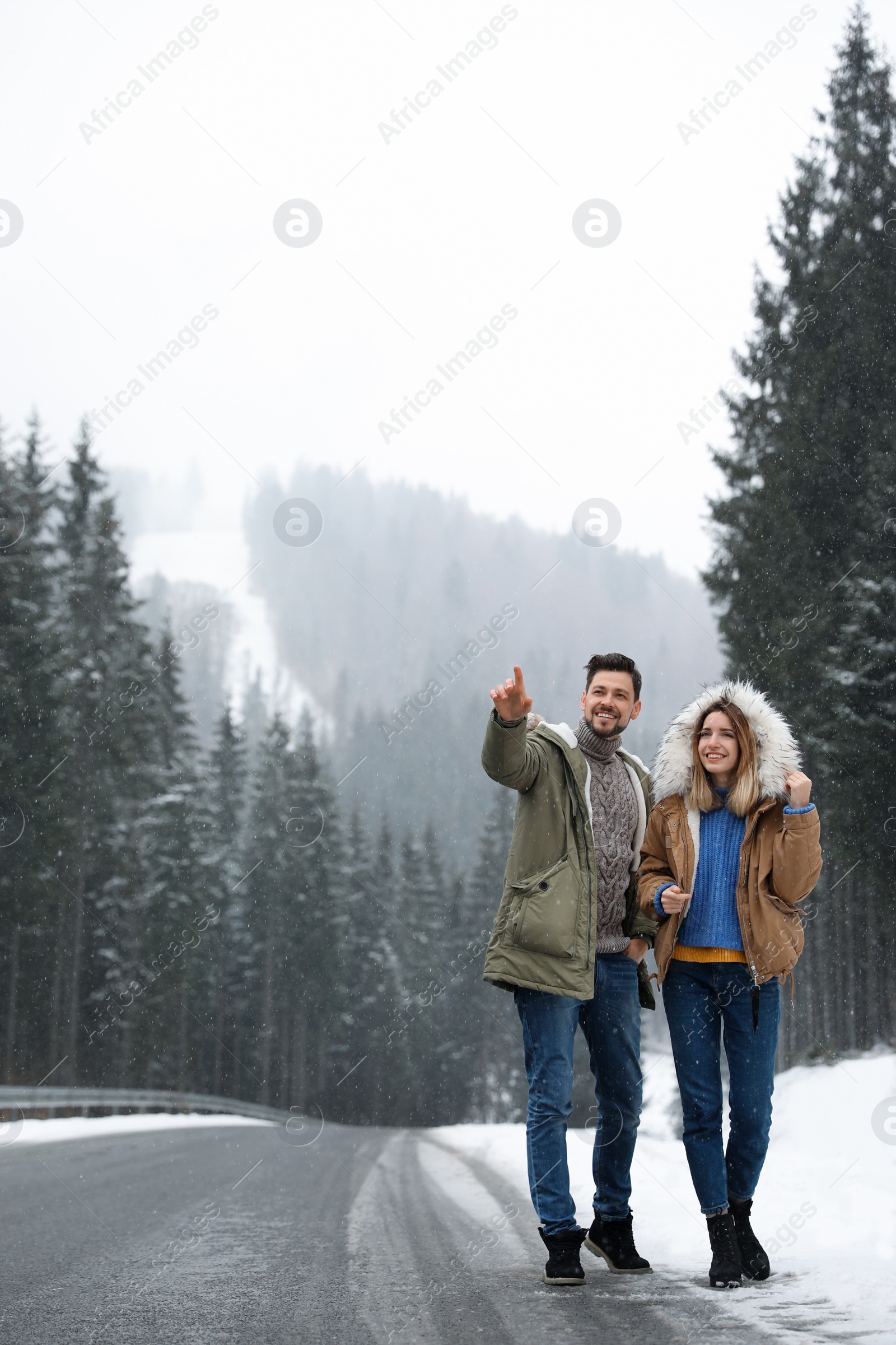 Photo of Couple walking near snowy forest. Winter vacation