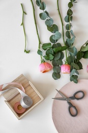 Professional florist workplace with beautiful flowers, ribbon and scissors, top view