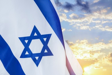 Image of National flag of Israel against blue sky with clouds
