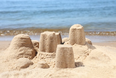 Photo of Little sand figures on beach near sea