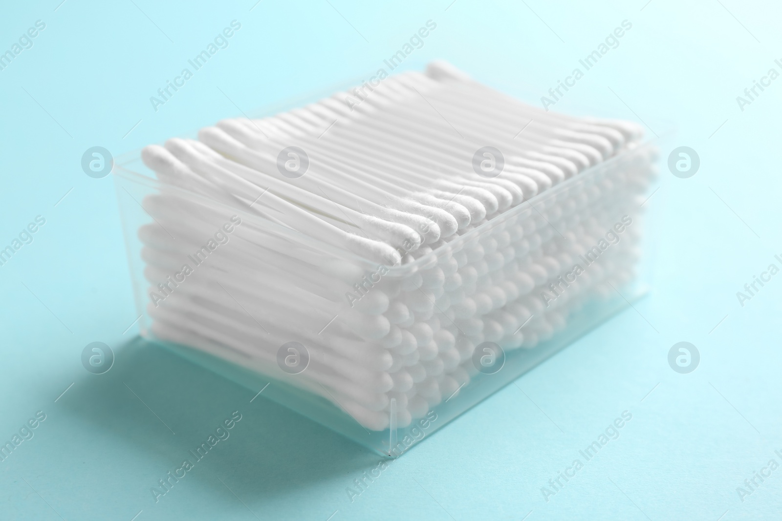 Photo of Plastic container with cotton swabs on color background