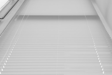 Stylish window with horizontal blinds, low angle view