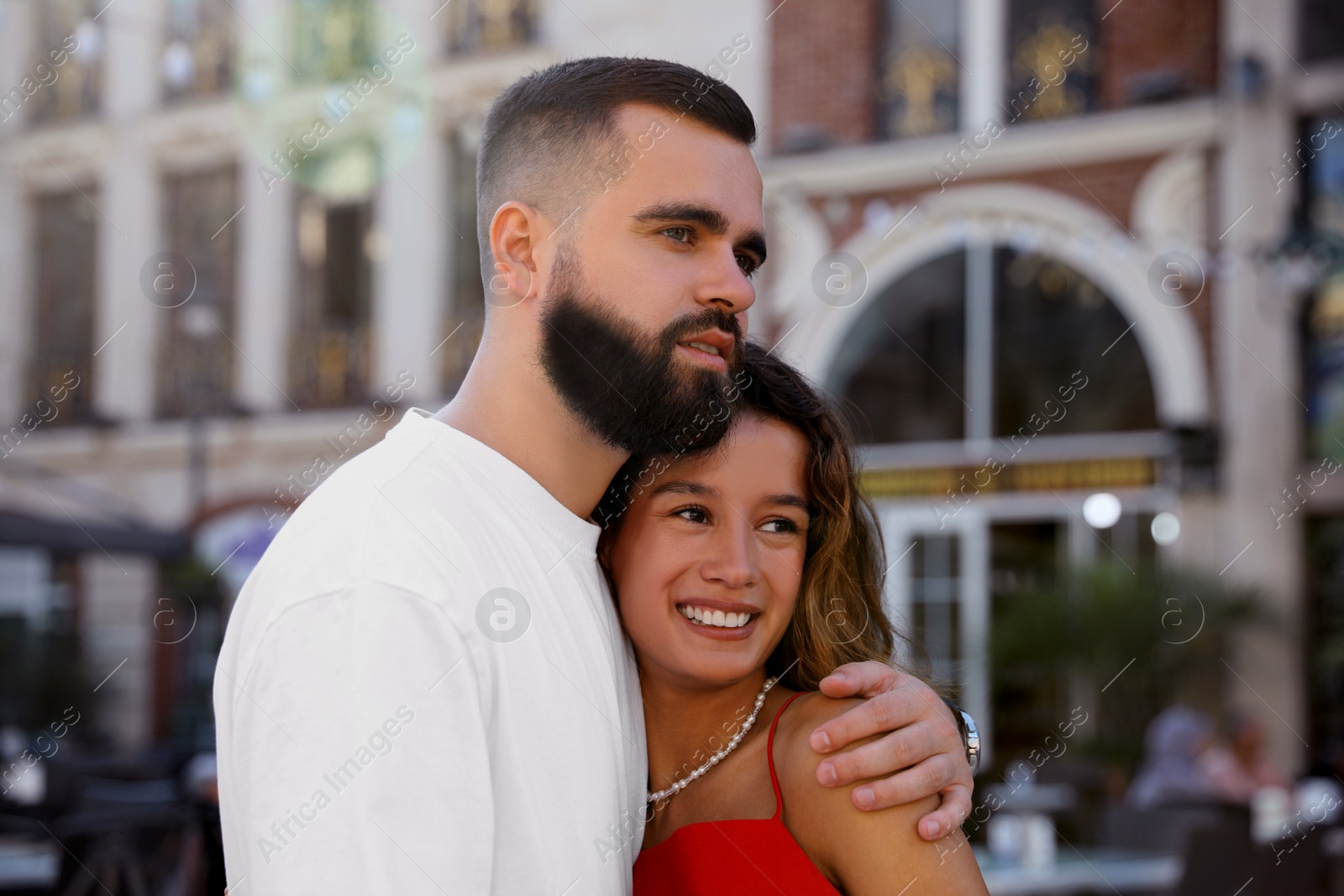 Photo of Happy young couple hugging on city street