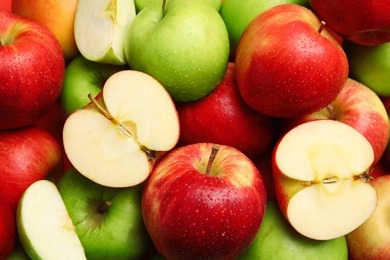 Many different whole and cut apples as background, closeup