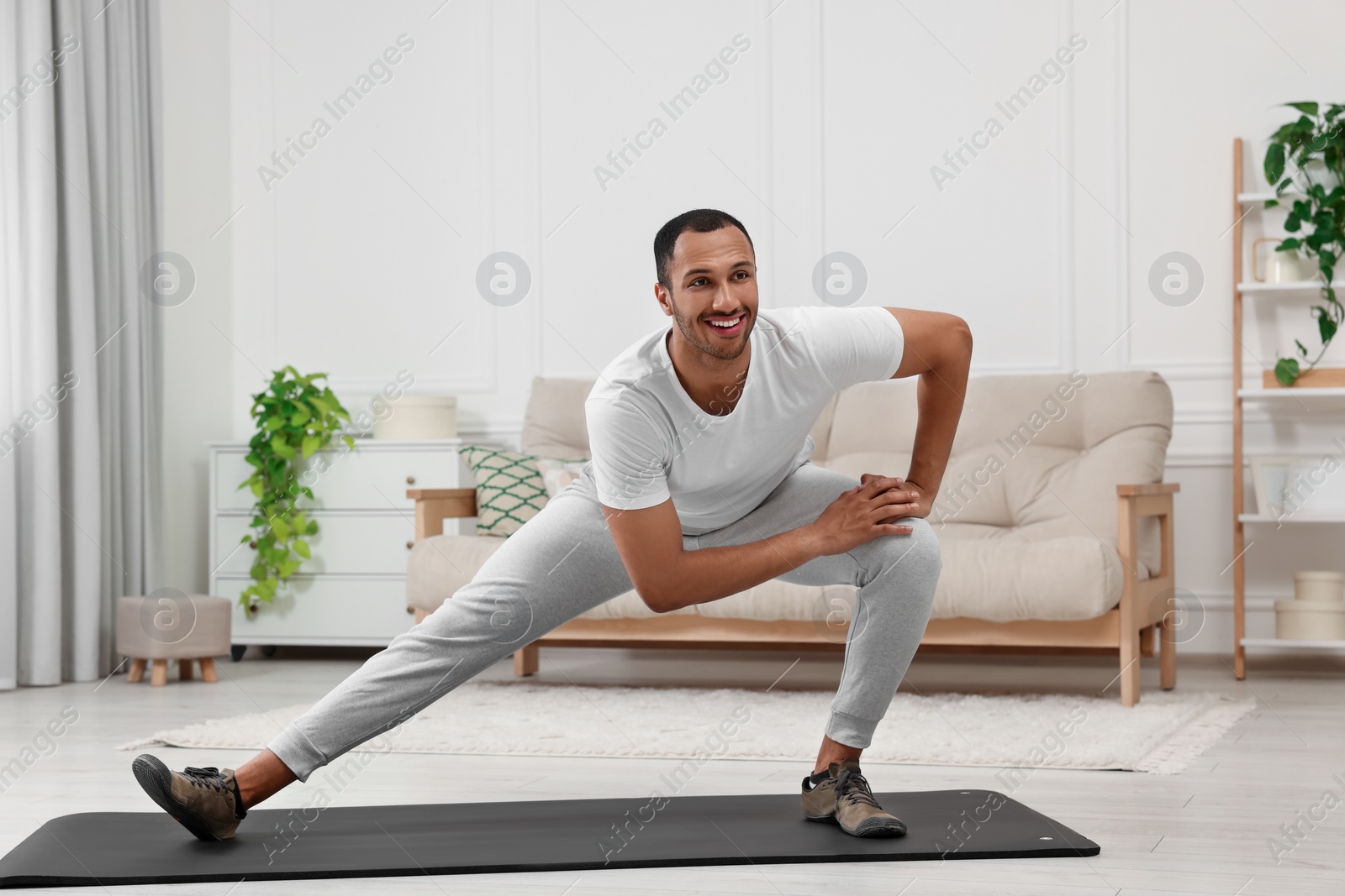 Photo of Man doing morning exercise on fitness mat at home