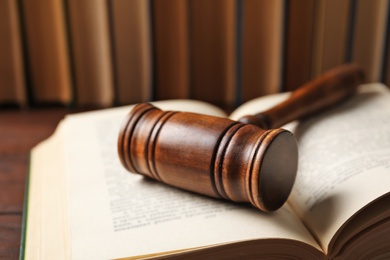 Photo of Wooden gavel and books on table, closeup. Law concept