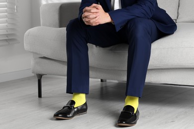 Photo of Man wearing stylish shoes and yellow socks at home, closeup