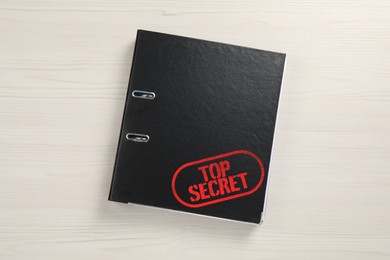 Image of Top Secret stamp. Office folder on white wooden table, top view