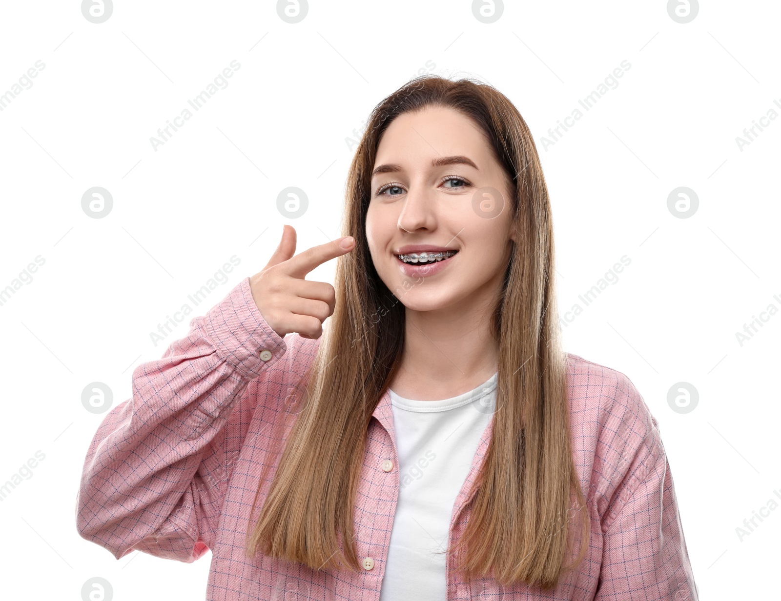 Photo of Portrait of smiling woman pointing at her dental braces on white background