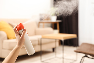 Photo of Woman spraying air freshener at home, closeup