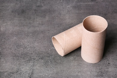 Photo of Empty toilet paper rolls and space for text on gray background