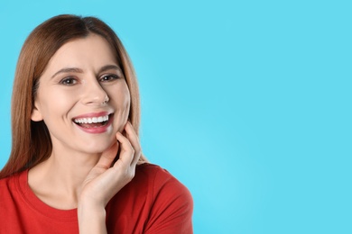 Smiling woman with perfect teeth on color background. Space for text