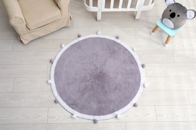 Photo of Stylish soft rug on floor in baby room, above view