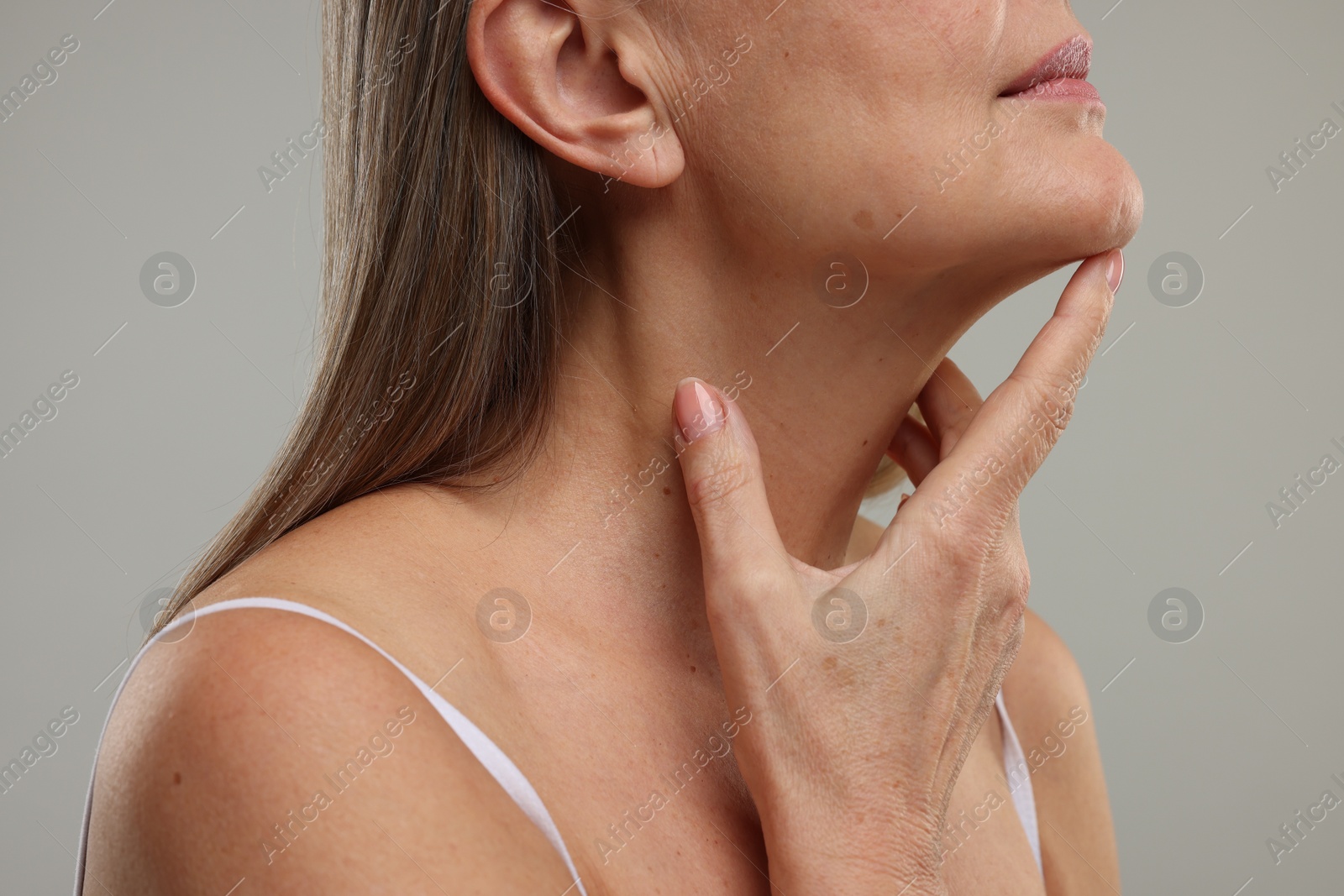 Photo of Mature woman with healthy skin on grey background, closeup