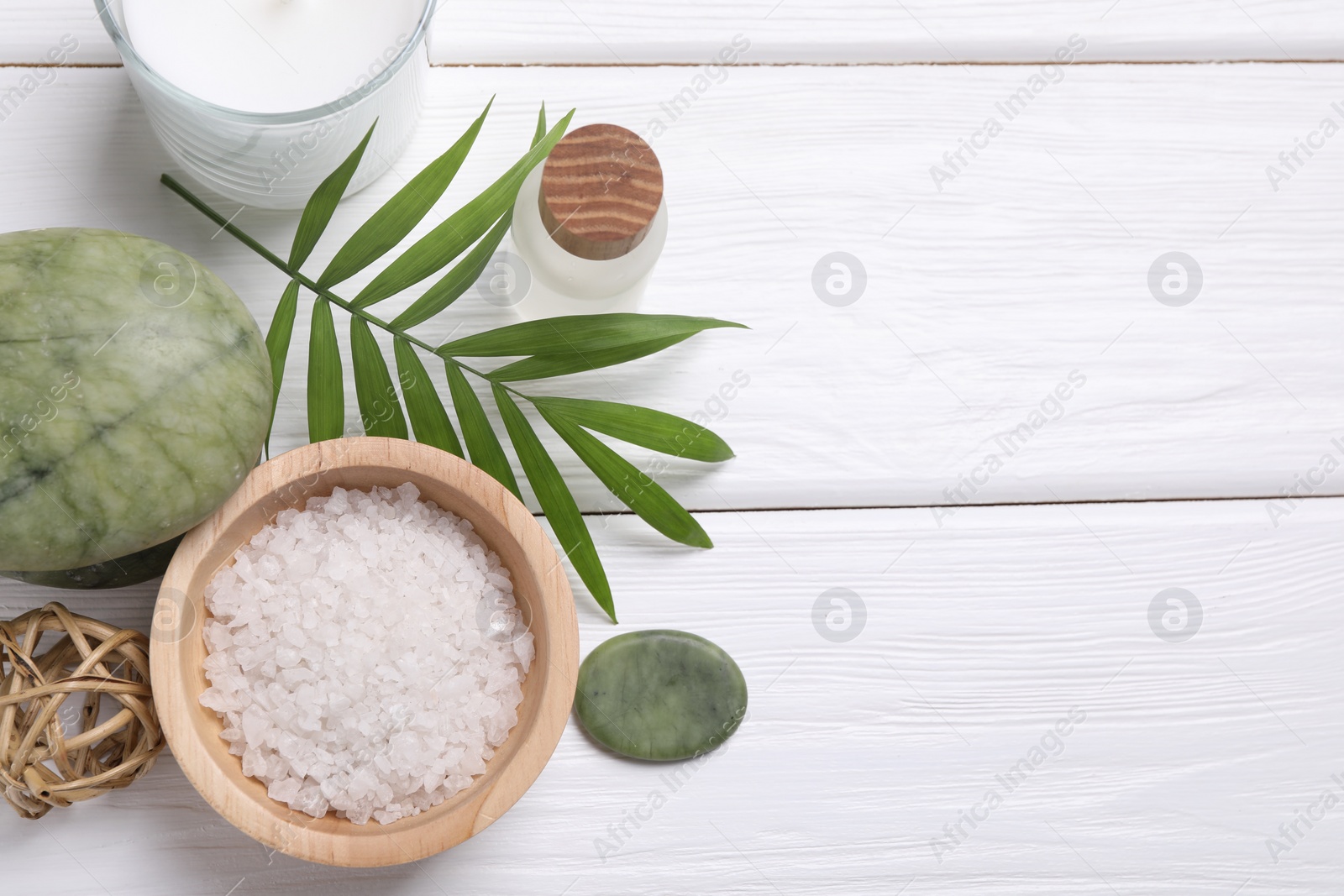 Photo of Flat lay composition with candle and different spa products on white wooden table. Space for text