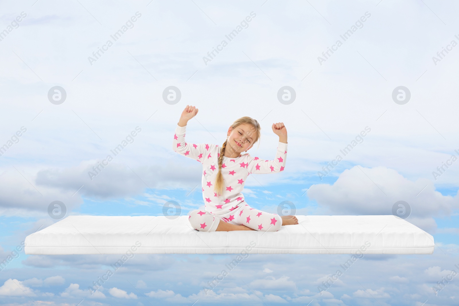 Image of Healthy sleep. Little girl waking up on comfortable mattress in blue sky