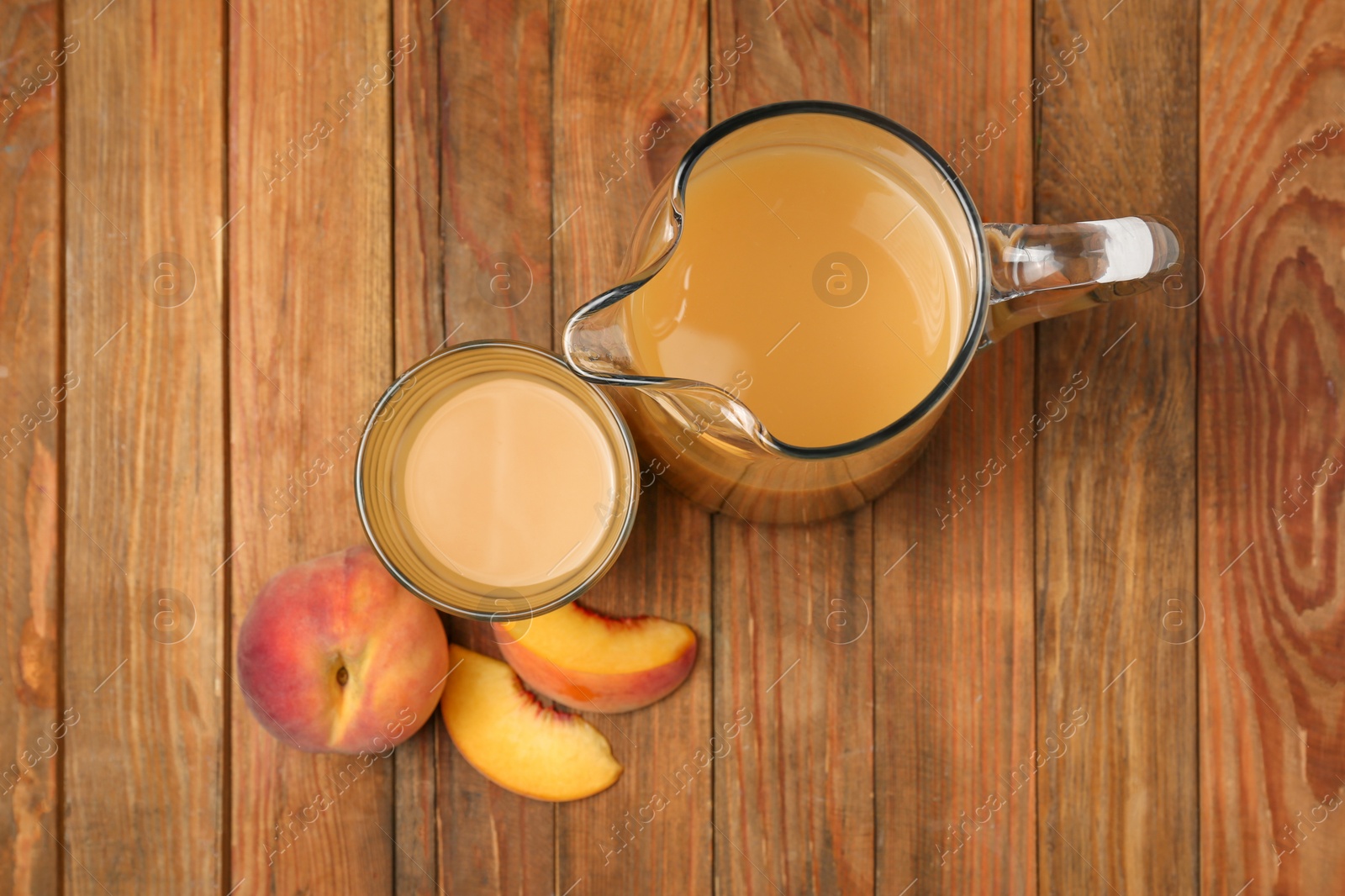 Photo of Delicious peach juice and fresh fruits on wooden table, flat lay