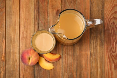 Photo of Delicious peach juice and fresh fruits on wooden table, flat lay