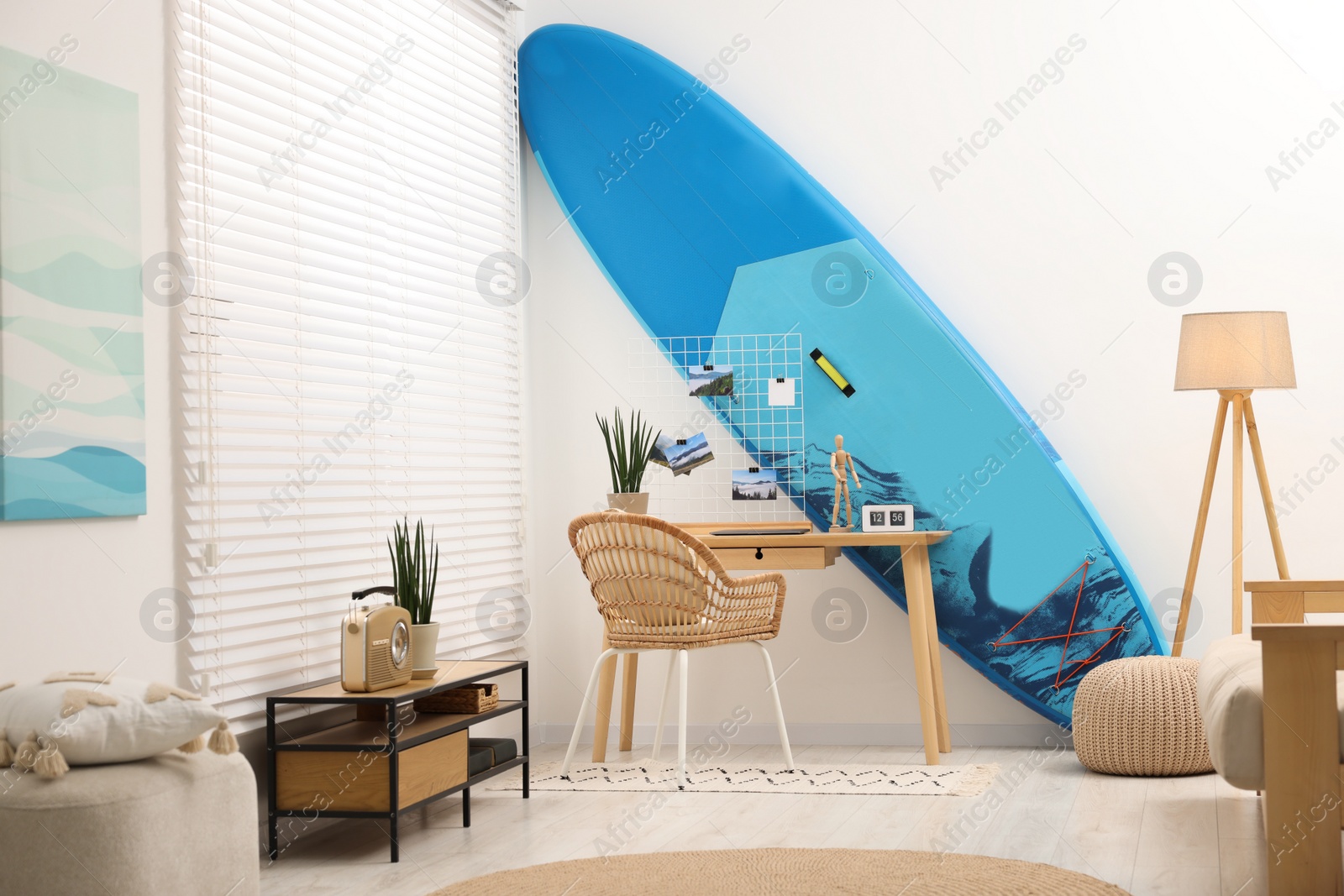 Photo of SUP board and workplace in room. Interior design