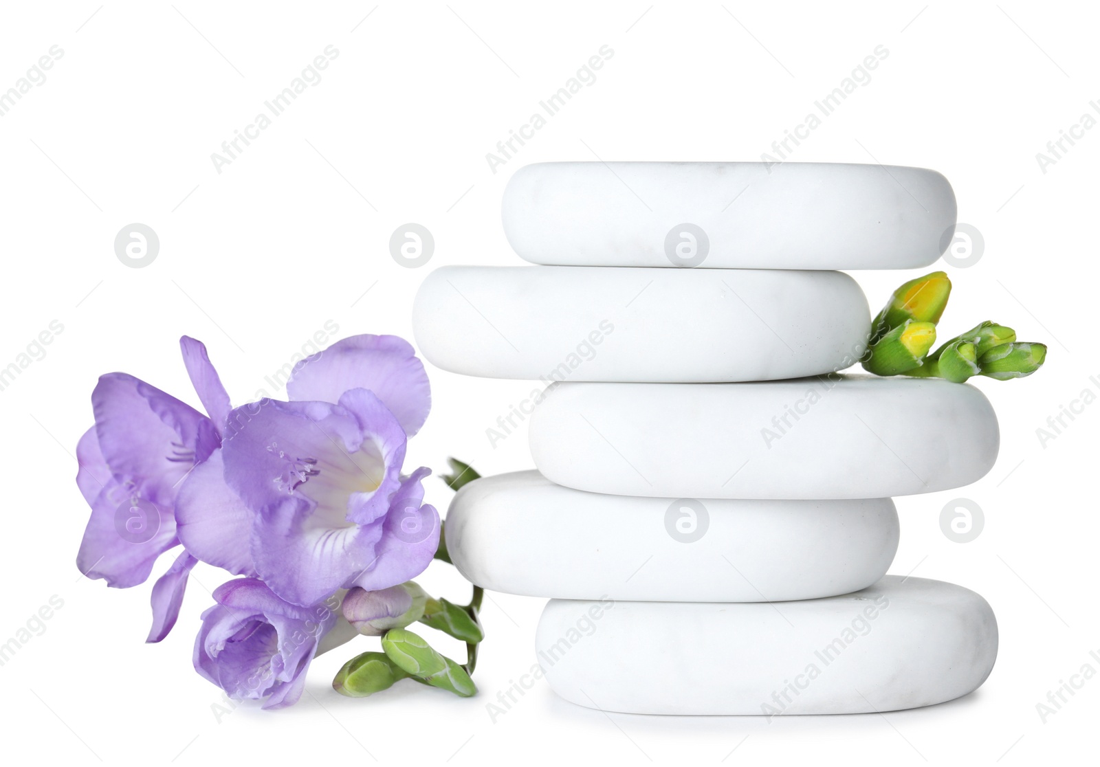 Photo of Stack of spa stones and beautiful flowers on white background