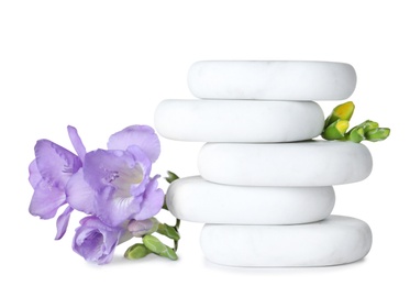 Stack of spa stones and beautiful flowers on white background