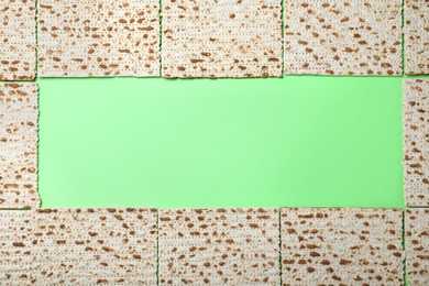 Photo of Frame of traditional matzos on green background, flat lay. Space for text