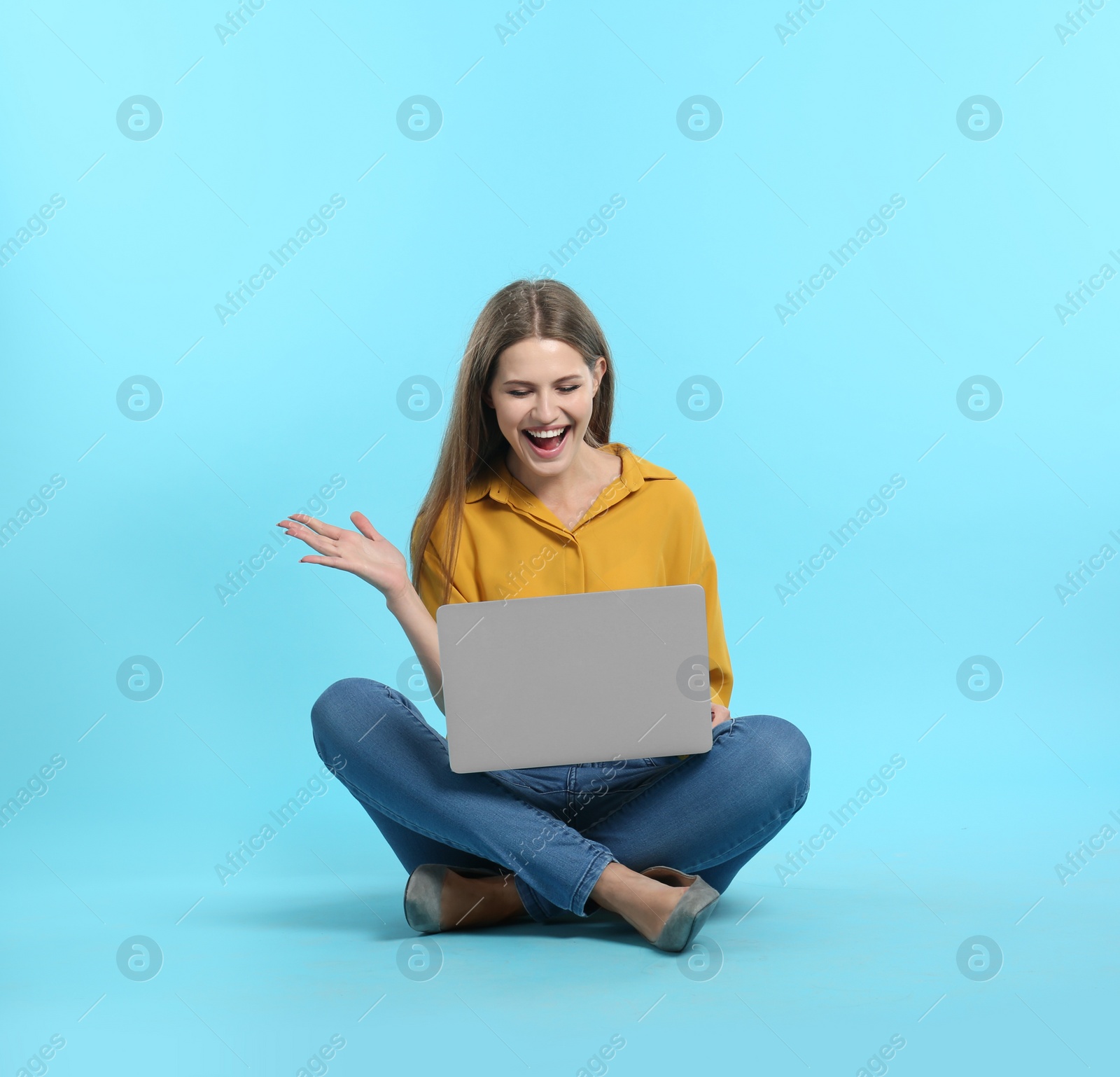 Photo of Emotional young woman with laptop celebrating victory on color background