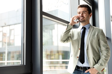 Male business trainer talking on phone in office