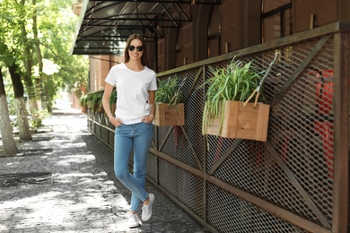 Photo of Young woman wearing white t-shirt on street