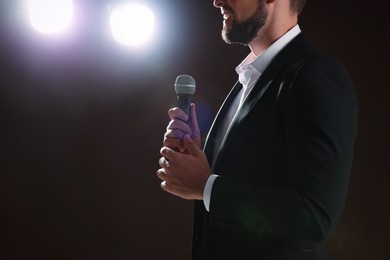 Photo of Motivational speaker with microphone performing on stage, closeup. Space for text