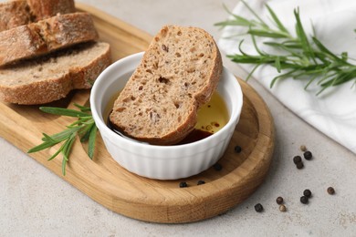 Photo of Bowl of organic balsamic vinegar with oil served with spices and bread slices on beige table