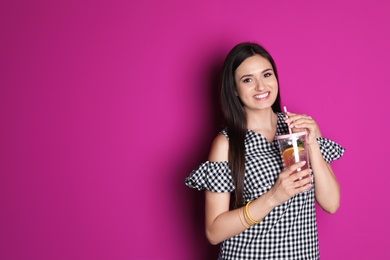 Young woman with tasty lemonade on color background. Natural detox drink