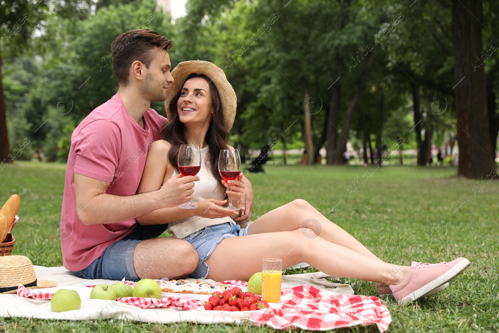 Photo of Happy young couple having picnic in park on summer day