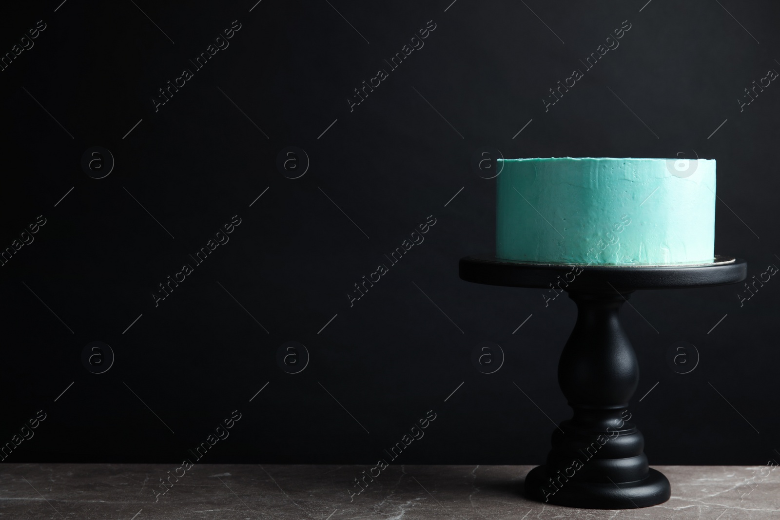 Photo of Fresh delicious birthday cake on stand against black background. Space for text