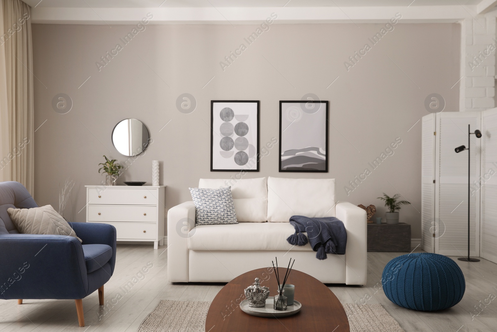 Photo of Stylish living room interior with white sofa, armchair and beautiful pictures