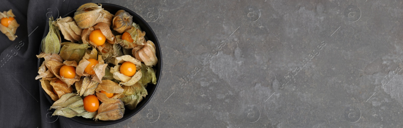 Image of Ripe physalis fruits on grey table, flat lay with space for text. Banner design