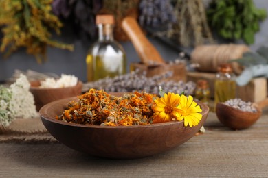 Photo of Bowl and different herbs on wooden table